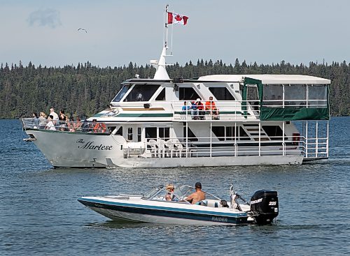 Brandon Sun The Martese cruise ship sails into the pier at Clear Lake beach past a motorboat at the main beach in Wasagaming, Saturday afternoon in the August long weekend in 2015. (Colin Corneau/Brandon Sun)