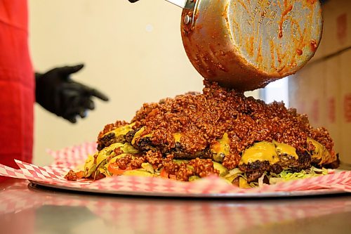 Mike Sudoma/Free Press
Manager Les Bartle pours 1.5 pounds of chilli onto of the massive burger, bringing it to close to the 12 pound mark
May 12, 2026
