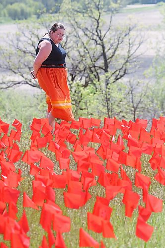 A woman looks at the field of orange flags on Wednesday afternoon. (Matt Goerzen/The Brandon Sun)