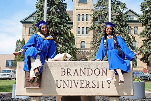 Edidiong Udah and Ada Okeke pose for photos on the Brandon University sign along 18th Street in front of Clark Hall after receiving their degrees from the bachelor of nursing program on Friday. (Tim Smith/The Brandon Sun)