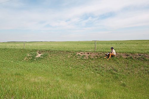 Smith is seen outside a fox den that he visits each spring to capture new litters. Smith said he sat for more than three hours at the location this year before capturing intimate photographs of fox kits playing. (Connor McDowell/The Brandon Sun)
