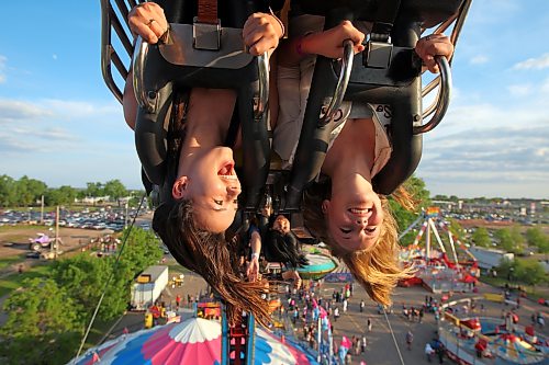 Two friends get an upside-down look at the Manitoba Summer Fair from the midway ride The Fireball in 2011. (Tim Smith/Brandon Sun)