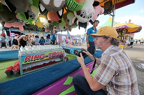 Smith is seen photographing the opening day of the Manitoba Summer Fair for the Brandon Sun on a Wednesday afternoon. A group of friends are seen playing ring toss. (Connor McDowell/The Brandon Sun)