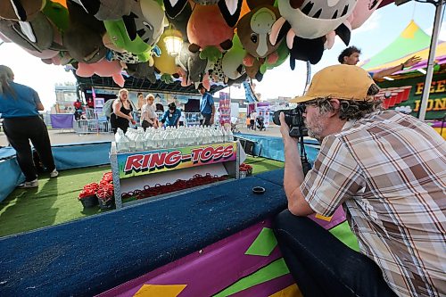 Smith is seen photographing the opening day of the Manitoba Summer Fair for the Brandon Sun on a Wednesday afternoon. A group of friends are seen playing ring toss. (Connor McDowell/The Brandon Sun)