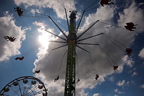Dark clouds provide a dramatic backdrop as fairgoers ride the Swing Tower midway ride at the Manitoba Summer Fair on the Keystone Centre grounds on Wednesday. (Tim Smith/The Brandon Sun)