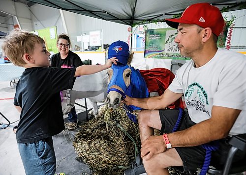 JOHN WOODS / FREE PRESS
Charlie Macdonald tries his hat on Minature Horse Macho as Ryan Steele and Candice Cronin, owners of Wild Willow Ranch and Rescue, look on during the Manitoba Pet Expo in St Norbert Community Club Sunday, June 7, 2026.
reporter: standup