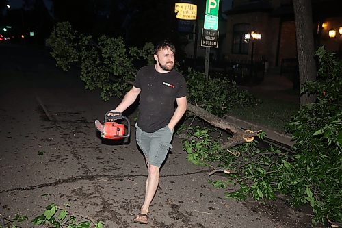 09062026
Brandonite Nick Duval uses a chainsaw to cut away branches on a tree that fell and blocked the southbound lanes of 18th Street just south of Rosser Avenue during Tuesday evening’s storm. Duval was driving by and pulled over and volunteered to help clear the street along with Brandon Police Service officers. 
(Tim Smith/The Brandon Sun)