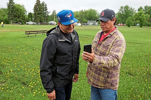10062026
Minitonas resident Jesse R. Genaille shows Manitoba Premier Wab Kinew a video of the flooding at his home on Wednesday while the Premier toured the damage caused by flooding in the area over the past few days.
(Tim Smith/The Brandon Sun)