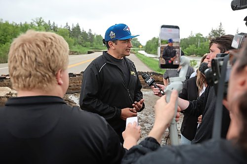 10062026
Manitoba Premier Wab Kinew talks to journalists while touring damage to Highway 10 at Tamarack Creek just east of Swan River, Manitoba on Wednesday after intense rainfall this week caused the river to swell and damaged the highway. The province cut a section of Highway 10 at the creek to relieve some of the pressure from the swollen creek.
(Tim Smith/The Brandon Sun)