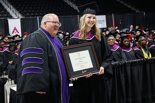 Business administration–accounting graduate Kristina Ivanova receives the Governor General’s Medal plaque from Assiniboine College president Mark Frison during Friday morning's ceremony. (Abiola Odutola/The Brandon Sun)