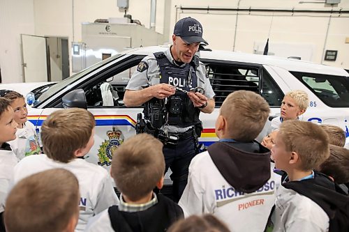 Const. Terry Fehr with the Neepawa RCMP detachment shows students how handcuffs work while talking about his role as an RCMP officer. (Tim Smith/The Brandon Sun)