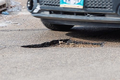 MIKE DEAL / FREE PRESS
Vehicles dodge a pothole on Roslyn Road at Osborne Street Monday morning.
260323 - Monday, March 23, 2026.