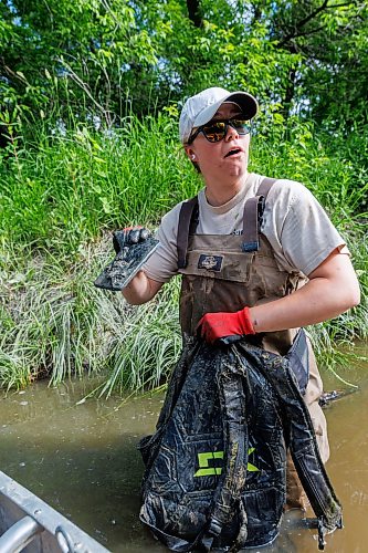 MIKE DEAL / FREE PRESS
Nastassja Loiselle, Lead Hand with the Save Our Seine cleanup crew, emptying a backpack full of water discovers that it contains a bunch of someone’s personal items including a phone and earbuds, Thursday morning. The crew of usually three is out most nice days paddling their way along the Seine River filling up their canoe with heaps of garbage. The portion of the Seine River in the city they are charged with protecting is about 26kms long and they will cover that distance at least four times during the next few months removing garbage and making sure the river is kept as healthy as possible..
