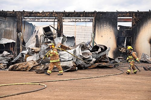 Firefighters move a hose at the scene of Thursday's fire on Green Acres Colony. (Tim Smith/The Brandon Sun)