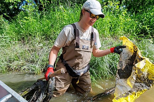 MIKE DEAL / FREE PRESS
Nastassja Loiselle, Lead Hand with the Save Our Seine cleanup crew, gets out of the canoe to pick up some trash caught in a tree Thursday morning. The crew of usually three is out most nice days paddling their way along the Seine River filling up their canoe with heaps of garbage. The portion of the Seine River in the city they are charged with protecting is about 26kms long and they will cover that distance at least four times during the next few months removing garbage and making sure the river is kept as healthy as possible..
