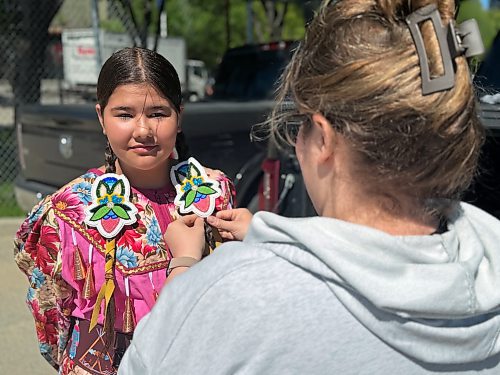 MORGAN MODJESKI / FREE PRESS
Alea Elliott, helps her daughter Sofia Ducharme, get ready to dance at the Wáhkóhtowin Powwow as part of Indigenous Peoples Day celebrations at the Forks in Winnipeg on June 21, 2026.