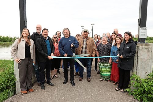22062026
Brandon Mayor Jeff Fawcett prepares to cut a ribbon while surrounded by other dignitaries during an event at the Riverbank Discovery Centre on Monday morning to announce the adding of five city-owned lands to Manitoba’s Protected and Conserved Areas Network. 
 (Tim Smith/The Brandon Sun)