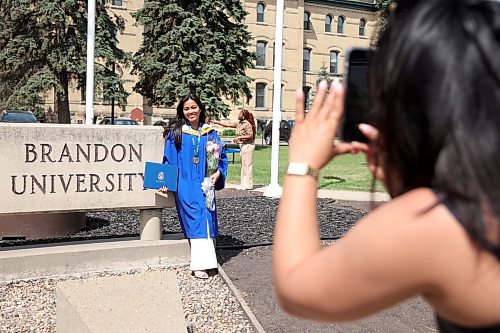 28052026
Divina Suazo has photos taken in front of the Brandon University sign along 18th Street in front of Clark Hall after receiving her degree from the Bachelor of Nursing program at Brandon University’s 2026 Convocation for the Faculty of Health Studies at the BU Healthy Living Centre on Thursday.
(Tim Smith/The Brandon Sun)