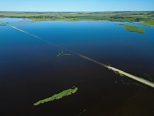 Floodwaters from the swollen Assiniboine River cover farmland and submerge portions of a grid road bisecting Highway 250 north of Alexander on Thursday. (Tim Smith/The Brandon Sun)