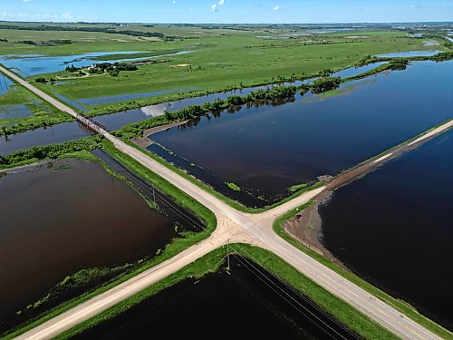 25062026
Flood waters from the swollen Assiniboine River cover farmland and submerge portions of a grid road bisecting Highway 250 north of Alexander on Thursday.
(Tim Smith/The Brandon Sun)default