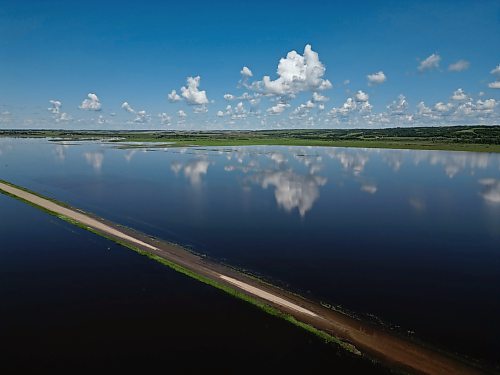 25062026
Flood waters from the swollen Assiniboine River cover farmland and submerge portions of a grid road near Highway 250 north of Alexander on Thursday.
(Tim Smith/The Brandon Sun)