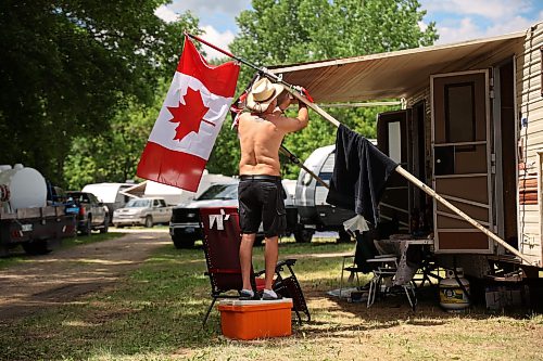 26062026
Lance Maxwell of Grandview, Manitoba stands on a cooler to hang Canadian flag decorations around his trailer on a sunny Friday afternoon at Dauphin’s Countryfest 2026.
 (Tim Smith/The Brandon Sun)