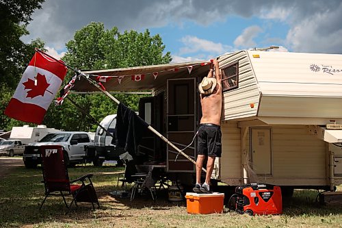 26062026
Lance Maxwell of Grandview, Manitoba stands on a cooler to hang Canadian flag decorations around his trailer on a sunny Friday afternoon at Dauphin’s Countryfest 2026.
(Tim Smith/The Brandon Sun)