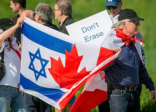 BROOK JONES/FREE PRESS
People gather outside the Canadian Museum for Human Rights along Israel Asper Way to protest a new exhibit, Palestine Uprooted - Nakba Past and Present, at the CMHR in Winnipeg, Man., Friday, June 26, 2026. Pictured: Leight Halprin (left) and Steven Raber carry a Canada-Israel flag.