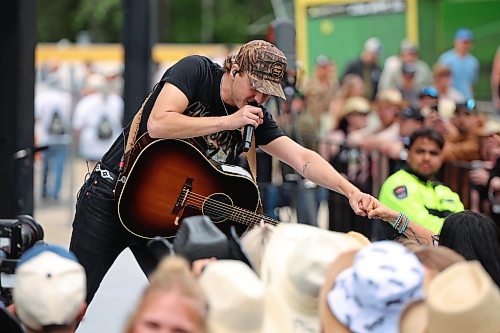 26062026
Canadian country musician Owen Riegling fist-bumps a fan while performing on the main stage with his band during light rain at Dauphin’s Countryfest 2026 on Friday evening.
(Tim Smith/The Brandon Sun)