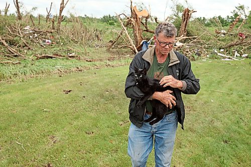 29062026
Brian Brown holds his cat Johnson after finding the cat under his home south of Rossburn, Manitoba on Monday after a powerful tornado hit the property on Sunday evening while Brian was at home with his wife Bernadine. Their home, several other buildings on the property, vehicles and hundreds of trees were all heavily damaged by the tornado. All of the Brown’s three house cats were found safe.
(Tim Smith/The Brandon Sun)