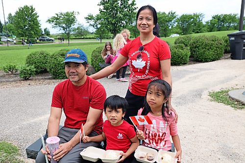 Marilou Buncal stands behind her husband Samie and two children, Ezeiah (centre) and Emia on Canada Day at the Riverbank Discovery Centre on Wednesday afternoon. (Tessa Adamski/The Brandon Sun)