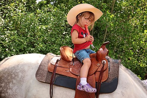 Two-year-old Thalia Passmore of Austin enjoys a freezie atop Julie, a quarter horse cross, at the Harding Fair on a hot and sunny afternoon. The fair is one of the stops in a week of agricultural fairs in Westman known as The Milk Run.
(Tim Smith/The Brandon Sun files)