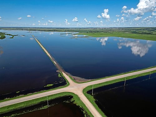 25062026
Flood waters from the swollen Assiniboine River cover farmland and submerge portions of a grid road bisecting Highway 250 north of Alexander on Thursday. 
(Tim Smith/The Brandon Sun)