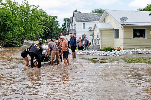 MIKE DEAL / FREE PRESS
Manitoba Premier Wab Kinew (left) helps a load a generator onto a canoe so it can be taken to a home only accessible by flooded streets in Swan River, MB.
Manitoba Premier Wab Kinew flew to Dauphin, MB and Swan River, MB on Thursday to get a first hand look at some of the flood damage and to meet with officials and victims who are still in the midst of dealing with the situation.
260702 - Thursday, July 02, 2026.