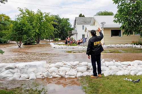 MIKE DEAL / FREE PRESS
Manitoba Premier Wab Kinew waves at a family on the other side of a flooded 3rd Street North in Swan River, MB, while sandbags protect nearby houses.
Manitoba Premier Wab Kinew flew to Dauphin, MB and Swan River, MB on Thursday to get a first hand look at some of the flood damage and to meet with officials and victims who are still in the midst of dealing with the situation.
260702 - Thursday, July 02, 2026.