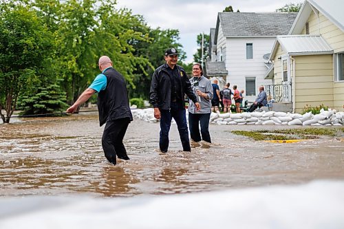 MIKE DEAL / FREE PRESS
Manitoba Premier Wab Kinew crosses back through flooded streets after helping move a generator.
Manitoba Premier Wab Kinew flew to Dauphin, MB and Swan River, MB on Thursday to get a first hand look at some of the flood damage and to meet with officials and victims who are still in the midst of dealing with the situation.
260702 - Thursday, July 02, 2026.