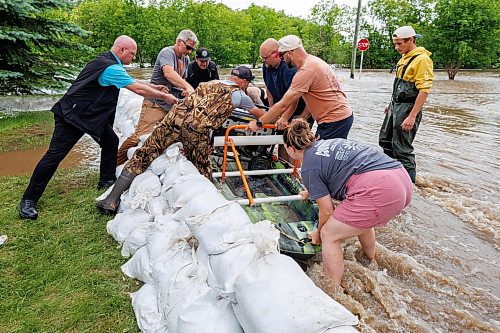 MIKE DEAL / FREE PRESS
Manitoba Premier Wab Kinew (centre) helps a load a generator onto a canoe so it can be taken to a home only accessible by flooded streets in Swan River, MB.
Manitoba Premier Wab Kinew flew to Dauphin, MB and Swan River, MB on Thursday to get a first hand look at some of the flood damage and to meet with officials and victims who are still in the midst of dealing with the situation.
260702 - Thursday, July 02, 2026.