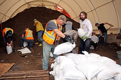 Volunteers and public works staff work to fill sandbags in Minnedosa on Friday as part of potential flood preparations. The Little Saskatchewan River is expected to continue to rise as water from all the recent rains in the area makes its way into the river and downstream. (Tim Smith/The Brandon Sun)