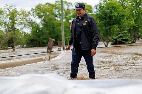 MIKE DEAL / FREE PRESS
Manitoba Premier Wab Kinew crosses back through flooded streets after helping move a generator.
Manitoba Premier Wab Kinew flew to Dauphin, MB and Swan River, MB on Thursday to get a first hand look at some of the flood damage and to meet with officials and victims who are still in the midst of dealing with the situation.
260702 - Thursday, July 02, 2026.