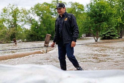 MIKE DEAL / FREE PRESS
Manitoba Premier Wab Kinew crosses back through flooded streets after helping move a generator.
Manitoba Premier Wab Kinew flew to Dauphin, MB and Swan River, MB on Thursday to get a first hand look at some of the flood damage and to meet with officials and victims who are still in the midst of dealing with the situation.
260702 - Thursday, July 02, 2026.