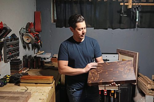 Jonathan Paddison, owner of Northern Prairie Woodworks, looks over a custom walnut end grain cutting board he made at his wood shop in Virden last month. 
(Tim Smith/The Brandon Sun)