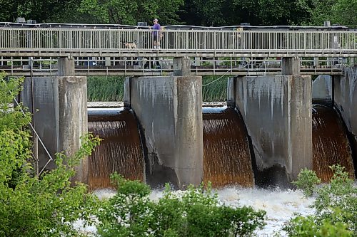 06072026
Visitors to the Minnedosa Lake dam pass over the spillway as water pours into the Little Saskatchewan River at an increased volume due to all the recent rain. 
(Tim Smith/The Brandon Sun)