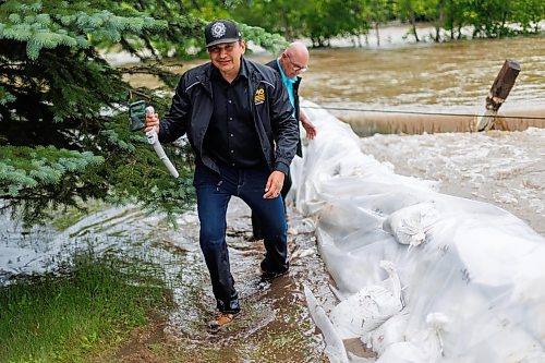 MIKE DEAL / FREE PRESS
Manitoba Premier Wab Kinew crosses back through flooded streets after helping move a generator.
Manitoba Premier Wab Kinew flew to Dauphin, MB and Swan River, MB on Thursday to get a first hand look at some of the flood damage and to meet with officials and victims who are still in the midst of dealing with the situation.
260702 - Thursday, July 02, 2026.