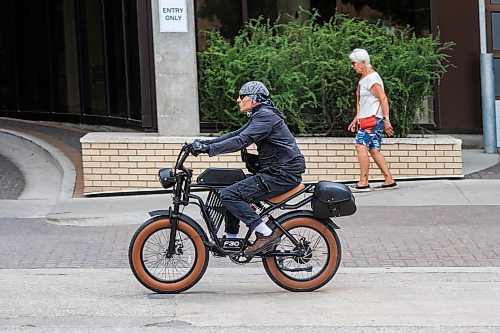 MIKE DEAL / FREE PRESS
An E-bike rider makes their way along Assiniboine Avenue Tuesday afternoon.
On the rise of e-bikes and scooters in Winnipeg and how the city/province plans to regulate them.
Reporter: Zoe Pierce
260707 - Tuesday, July 07, 2026.