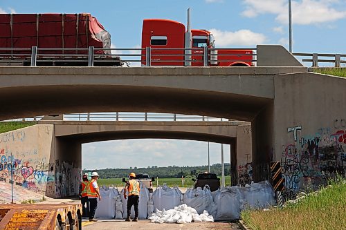 Workers install super sandbags to block off access to Grand Valley Road at the Trans-Canada Highway overpass on Wednesday as part of flood preparations. (Tim Smith/The Brandon Sun)

