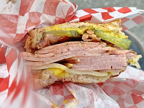 The Cubano sandwich at Sullivan’s Delights food truck is a hefty one: meaty layers of ham, bacon, pickles and Swiss cheese sandwiched between two slices of rye bread, slathered with your choice of mild or hot mustard. (Matt Goerzen/The Brandon Sun)