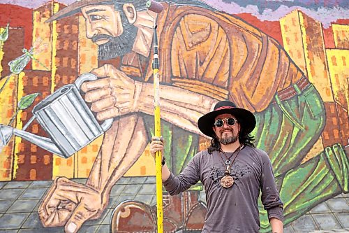 10072026
Miguel Rodriguez stands in front of his nearly complete mural, Building Brandon, on the side of the New System Store building along Rosser Avenue just west of Sixth Street on Friday.   (Tim Smith/The Brandon Sun)
***Please try to include portrait and one of the wide ones of him working on the whole mural