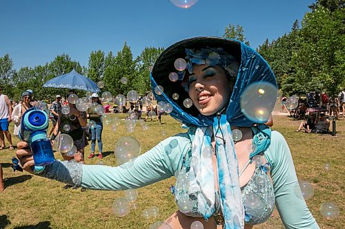 BROOK JONES/FREE PRESS
Folk Fest goer Lily Scott, who is from Edmonton, is pictured having fun with bubbles while watching Yagódy perform on the Snowberry Field Stage on an extremely hot day at the 51st edition of the Winnipeg Folk Festival at Birds Hill Provincial Park in Manitoba on Sunday, July 12, 2026.