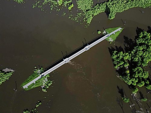 12072026
The foot bridge over the Assiniboine River at the Riverbank Discovery Centre is cut off on both sides by flood water on Sunday. (Tim Smith/The Brandon Sun)