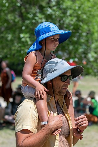 BROOK JONES/FREE PRESS
Folk Fest goer Ian Silver, 39, who is from St. Paul, Minn., is pictured with his two-year-old son Charlie Silver on his shoiulder while they listen to Yagódy perform on the Snowberry Field Stage on an extremely hot summer day at the 51st edition of the Winnipeg Folk Festival at Birds Hill Provincial Park in Manitoba on Sunday, July 12, 2026.